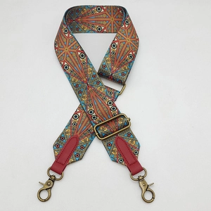 Close-up of bohemian wide bag strap with colorful geometric patterns and bronze hooks