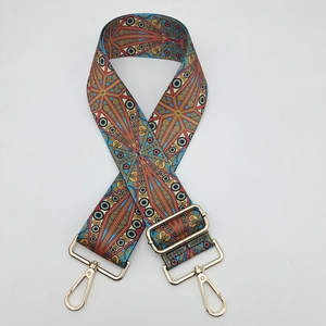 Detail of adjustable bohemian bag strap with colorful geometric patterns and gold metal hooks