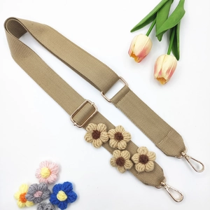 Détail de la bandoulière en toile kaki réglable avec fleurs au crochet et métal doré