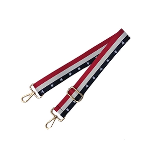 Detail view of striped nylon shoulder strap with blue stars and gold lobster clasps