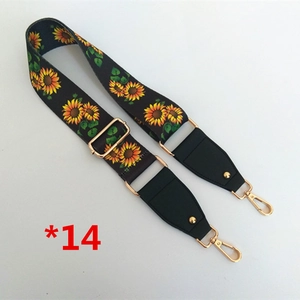 Détail d'une bandoulière noire réglable avec motif tournesol et crochets en métal doré brillant
