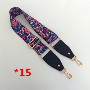 Détail de la bandoulière en tissu paisley réglable avec boucles dorées et cuir noir