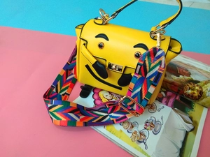 Détail de la bandoulière géométrique colorée sur le sac jaune avec fermoir en métal