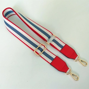 Dettaglio della tracolla regolabile in nylon a righe rosso bianco blu con ganci dorati
