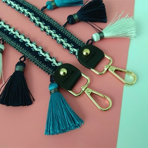 Detailansicht des ethnischen gewebten Taschenriemens mit bunten Quasten und Karabiner