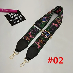 Detail of adjustable wide nylon bag strap with green butterfly pattern and gold metal hooks