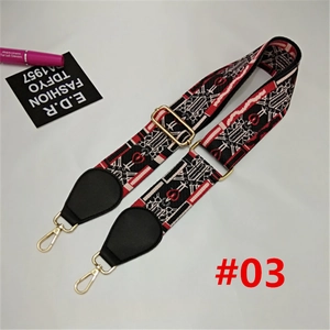 Detail view of woven nylon bag strap with red heart patterns and gold metal clasps