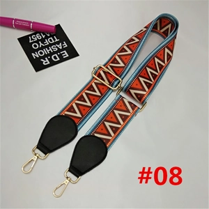 Detail of colorful geometric woven bag strap with golden lobster clasps and adjusters