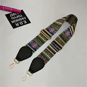 Close-up of colorful ethnic geometric woven strap with gold metal hooks and black leather