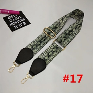 Detail of adjustable wide nylon bag strap featuring green snake skin pattern and gold hardware