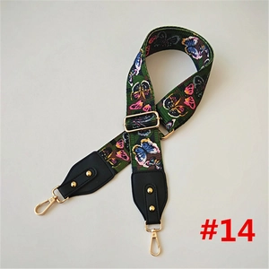 Detailed view of colorful butterfly canvas strap with gold swivel clips and leather ends