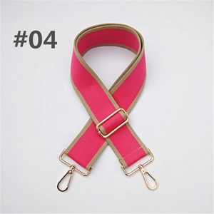 Close-up of adjustable wide canvas bag strap with pink webbing and gold metal hardware
