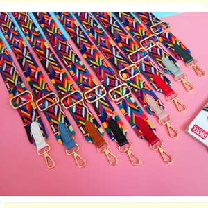 Detail of colorful geometric woven bag straps with gold metal hooks and leather ends