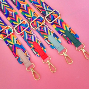 Detail of four colorful ethnic geometric canvas bag straps with gold metal buckles