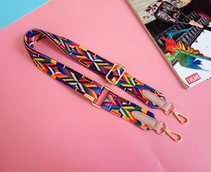 Close-up of colorful ethnic woven bag strap with golden metal lobster clasps