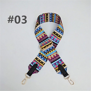 Close-up of ethnic geometric pattern strap with golden metal swivel hooks and leather ends