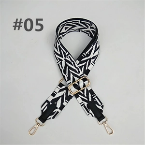 Detail of adjustable black and white ethnic pattern bag strap with gold metal hooks