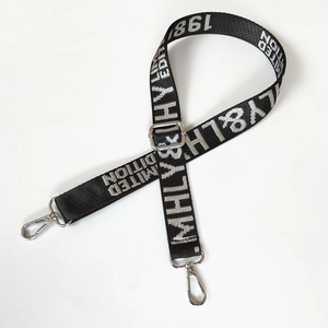 Detail of adjustable black nylon strap with white jacquard lettering and silver metal clips