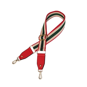 Adjustable striped woven bag strap with green-red pattern and gold metal hooks