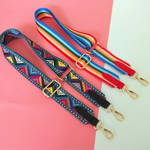 Close-up of adjustable woven bag straps with ethnic patterns and gold metal lobster clasps