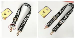Detail of adjustable black and white lettered nylon shoulder strap with gold metal hooks