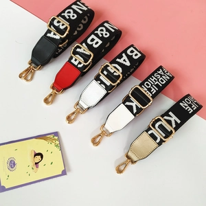 Detail of multi-color nylon bag straps with golden metal hooks and letter weaving pattern