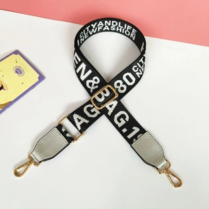 Detail of adjustable nylon shoulder strap with gold hardware and woven fashion letters