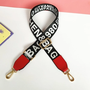 Detail showing adjustable black and white woven wide strap with red leather ends and gold clips