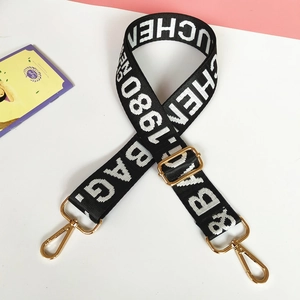 Adjustable black and white woven nylon strap with gold metal hooks and letter pattern