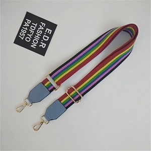 Detail of adjustable rainbow striped bag strap with blue leather and gold hardware