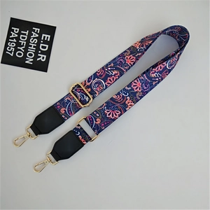 Detail view of adjustable ethnic print strap with gold lobster clasps and black leather ends