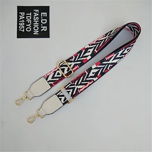 Close-up of ethnic geometric pattern strap with golden metal clasps for crossbody bags