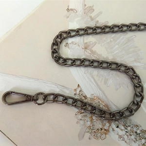 Detailed macro of gunmetal flat oval link chain strap with durable lobster clasp swivel hook