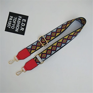 Close-up of geometric patterned strap with red leather and golden metal clasp for bags