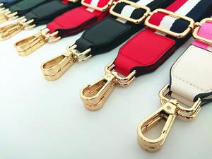 Close-up of adjustable colorful striped purse straps with gold swivel hooks and metal hardware
