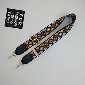 Detail of bohemian woven bag strap with colorful geometric patterns and gold metal swivel hook