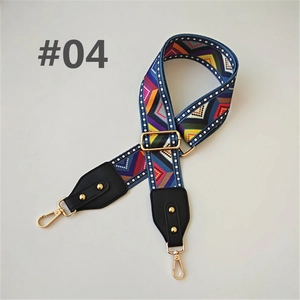 Close-up of colorful geometric woven bag strap with golden hardware and black leather ends