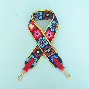 Nahaufnahme von dunkelblauem Segeltuchriemen mit Blumenmuster und goldenem Karabiner