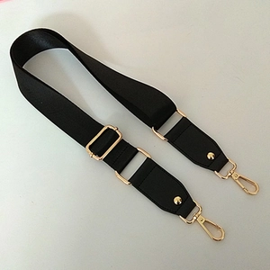 Détail de la bandoulière réglable en nylon noir avec attaches métalliques dorées
