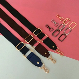 Détail des bandoulières réglables en nylon noir et marron avec boucles en métal et anneaux