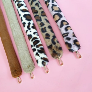 Detail view of five plush faux rabbit fur bag straps with gold metal lobster clasps