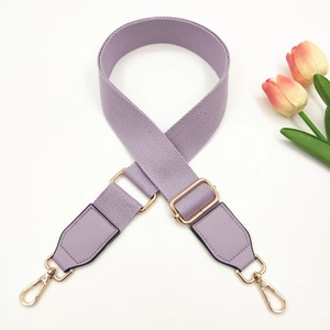 Détail de la bandoulière réglable en toile violette avec crochets en métal doré pour sacs