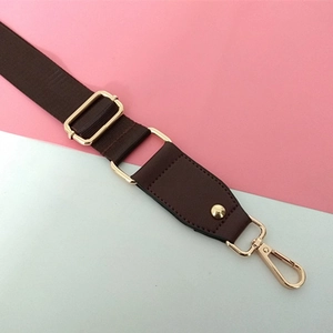 Détail de la bandoulière en nylon marron foncé avec boucle métallique dorée