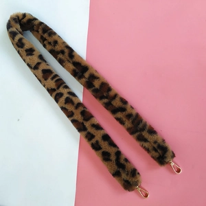 Close-up of faux fur leopard print bag strap with polished golden metal lobster clasps