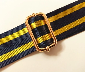 Detail of adjustable metal buckle on blue and yellow striped nylon bag shoulder strap