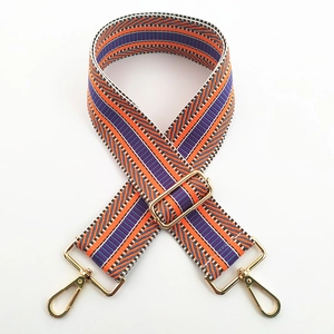 Close-up of colorful striped woven handbag strap with adjustable gold metal hardware