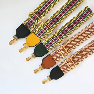 Detail view of five ethnic style embroidered bag straps with golden metal hooks