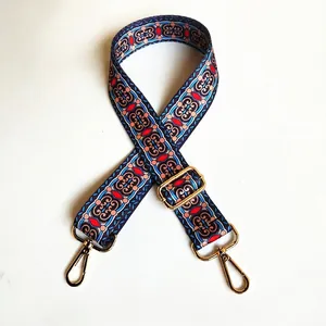 Detail view of ethnic style wide bag strap with bohemian pattern and golden metal hardware