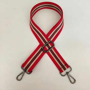 Détail de la bandoulière tissée réglable avec rayures rouges et vertes et mousquetons