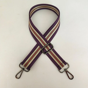 Détail de la bandoulière rayée réglable avec mousquetons métalliques et boucle solide